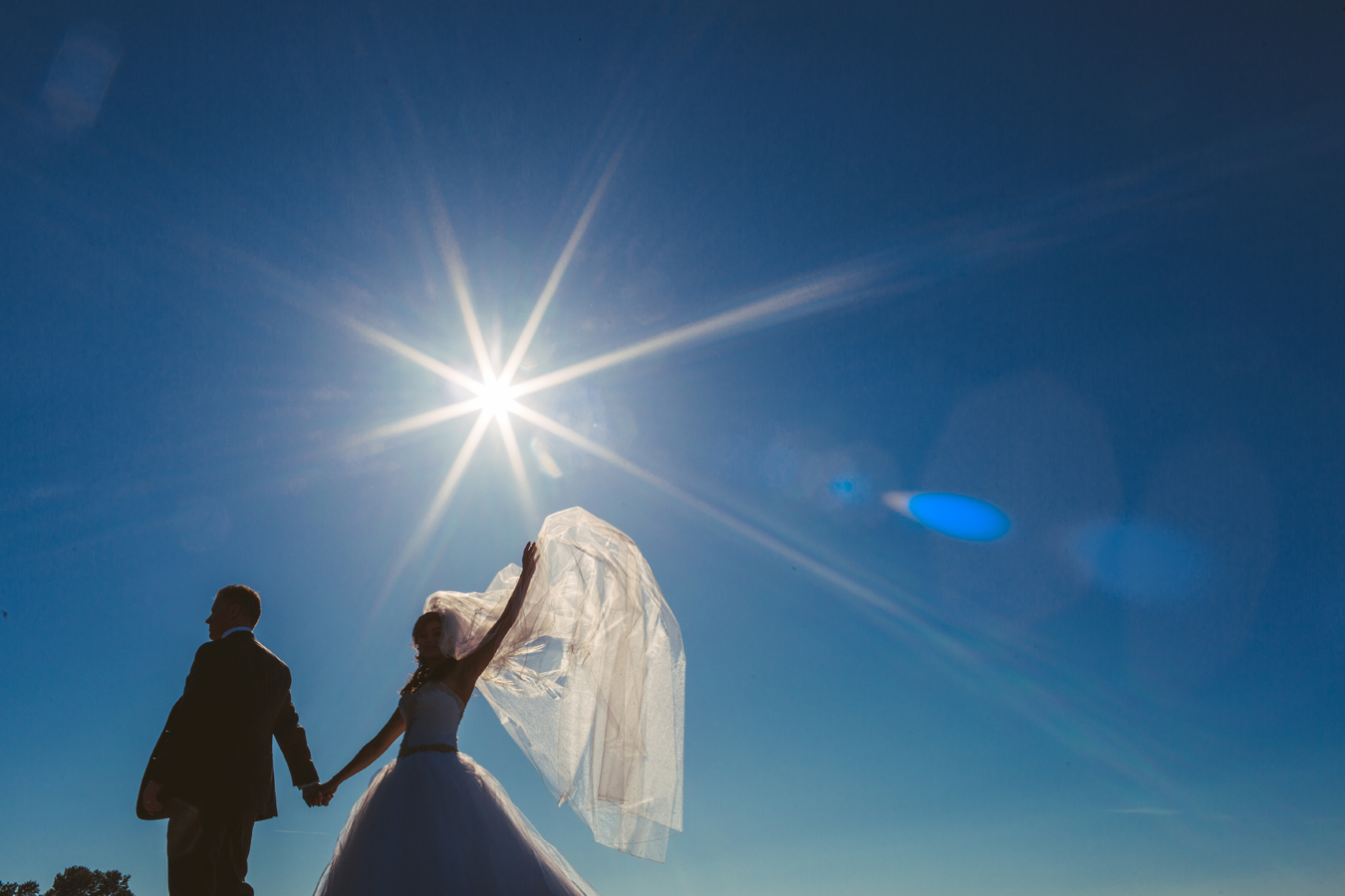 Bride and groom wave to wedding party