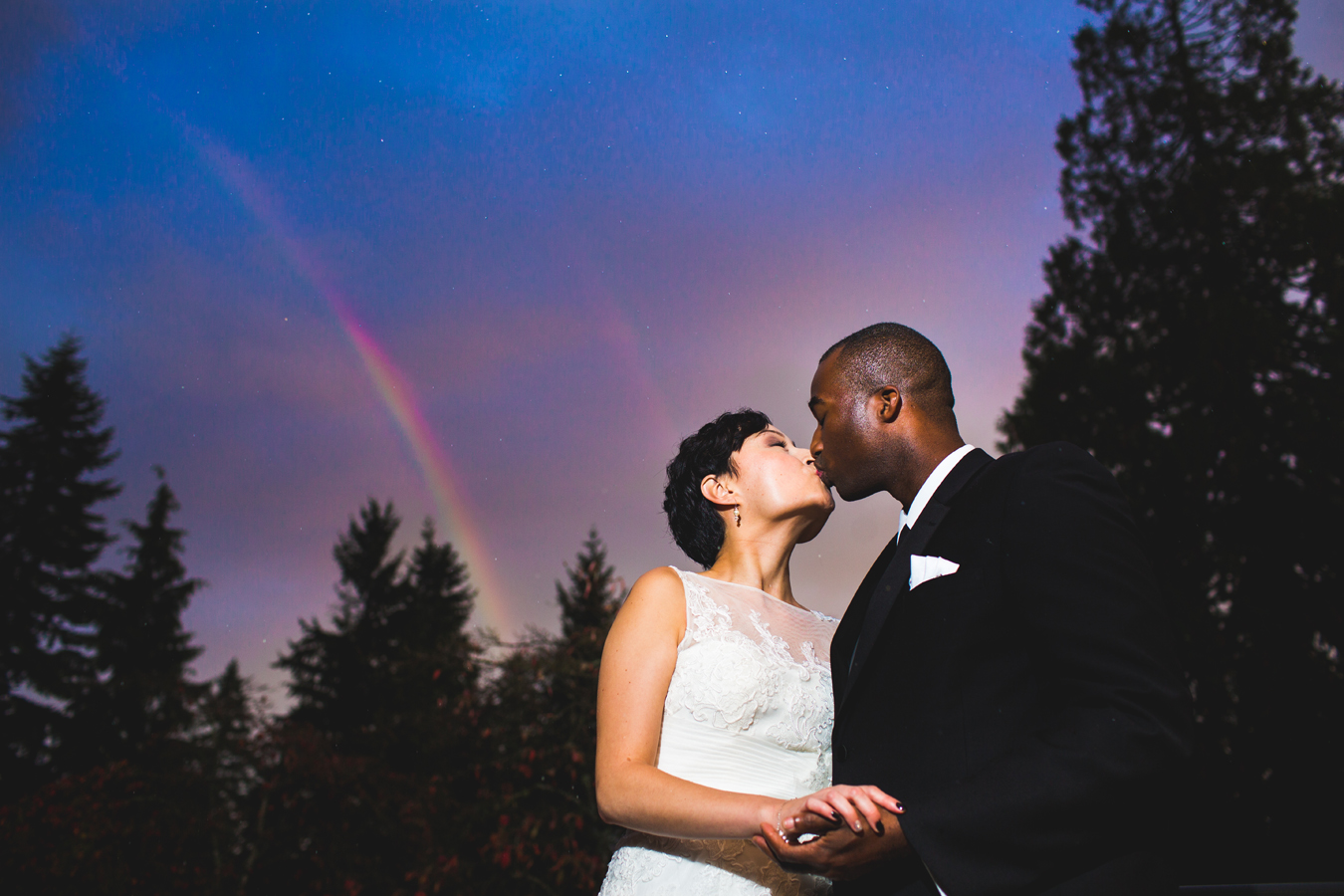 bride and groom with rainbow