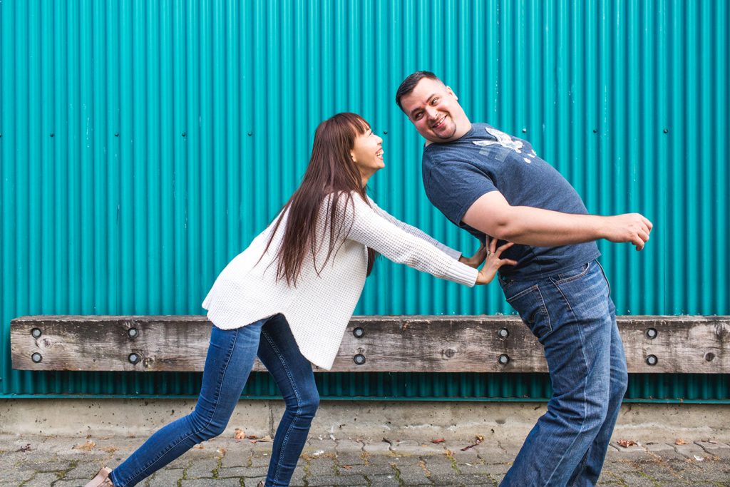 A woman playfully pushes her fiance at Granville Island