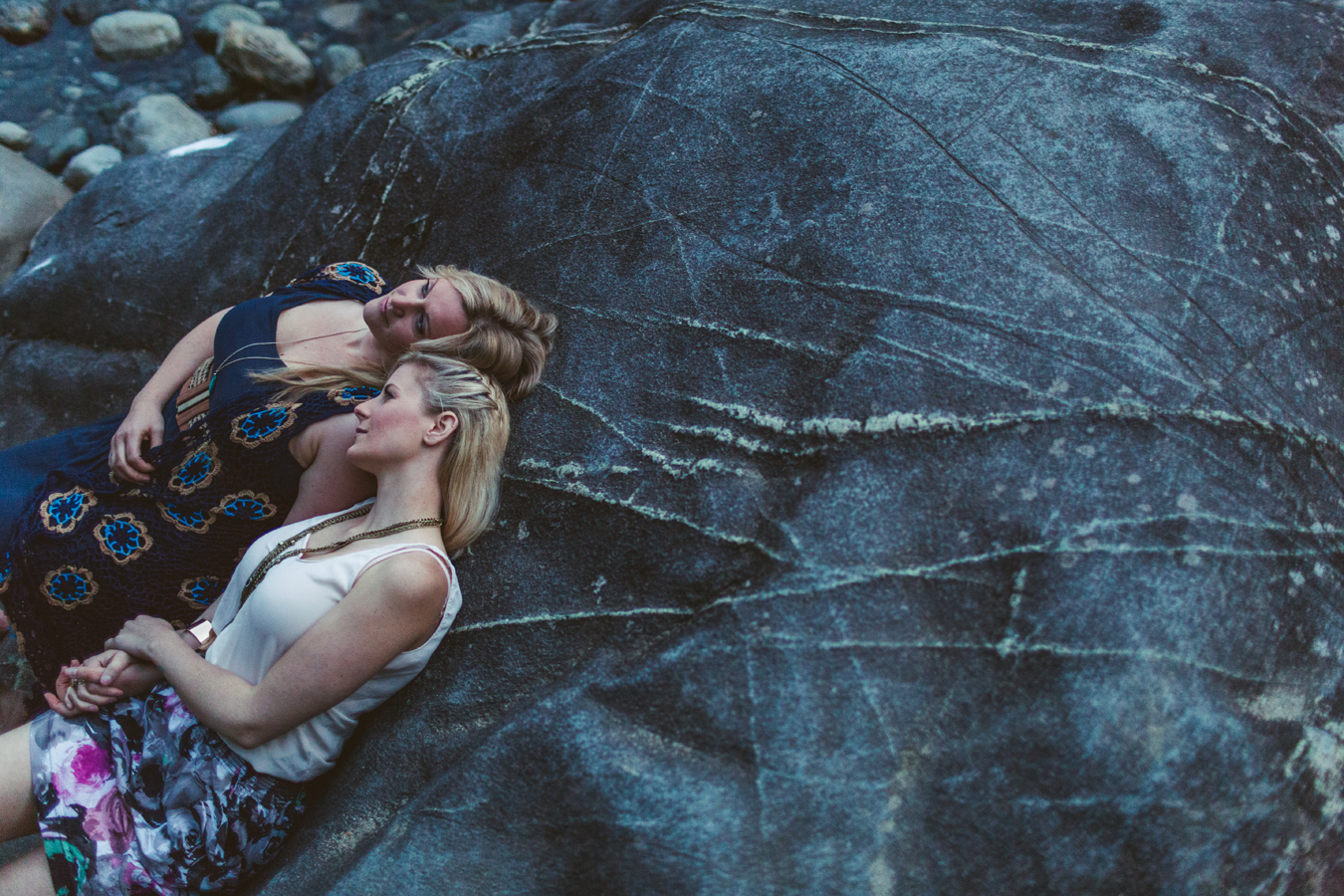 lesbian couple cuddles on a rock