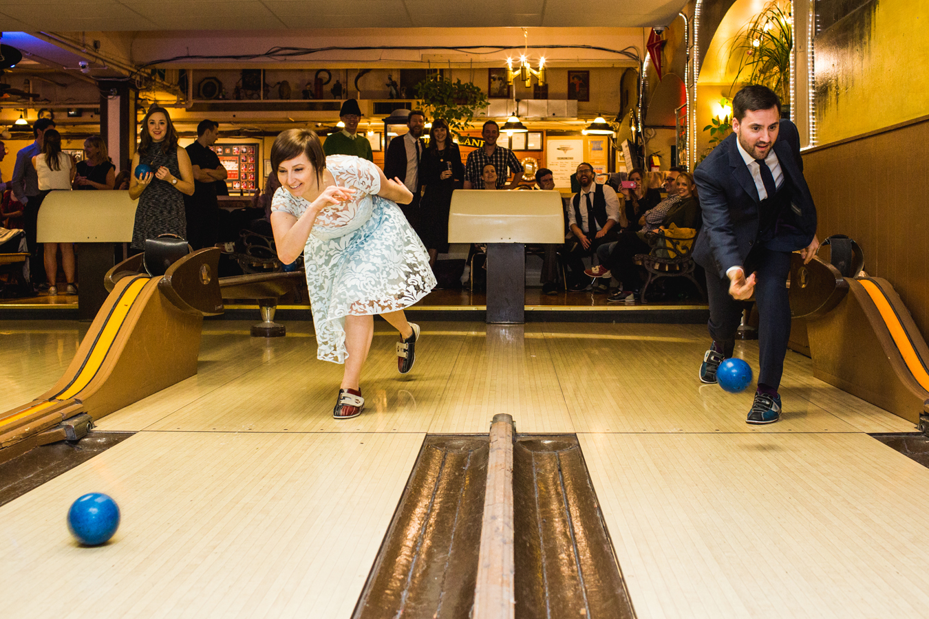 candid wedding photographer shoots couple bowling