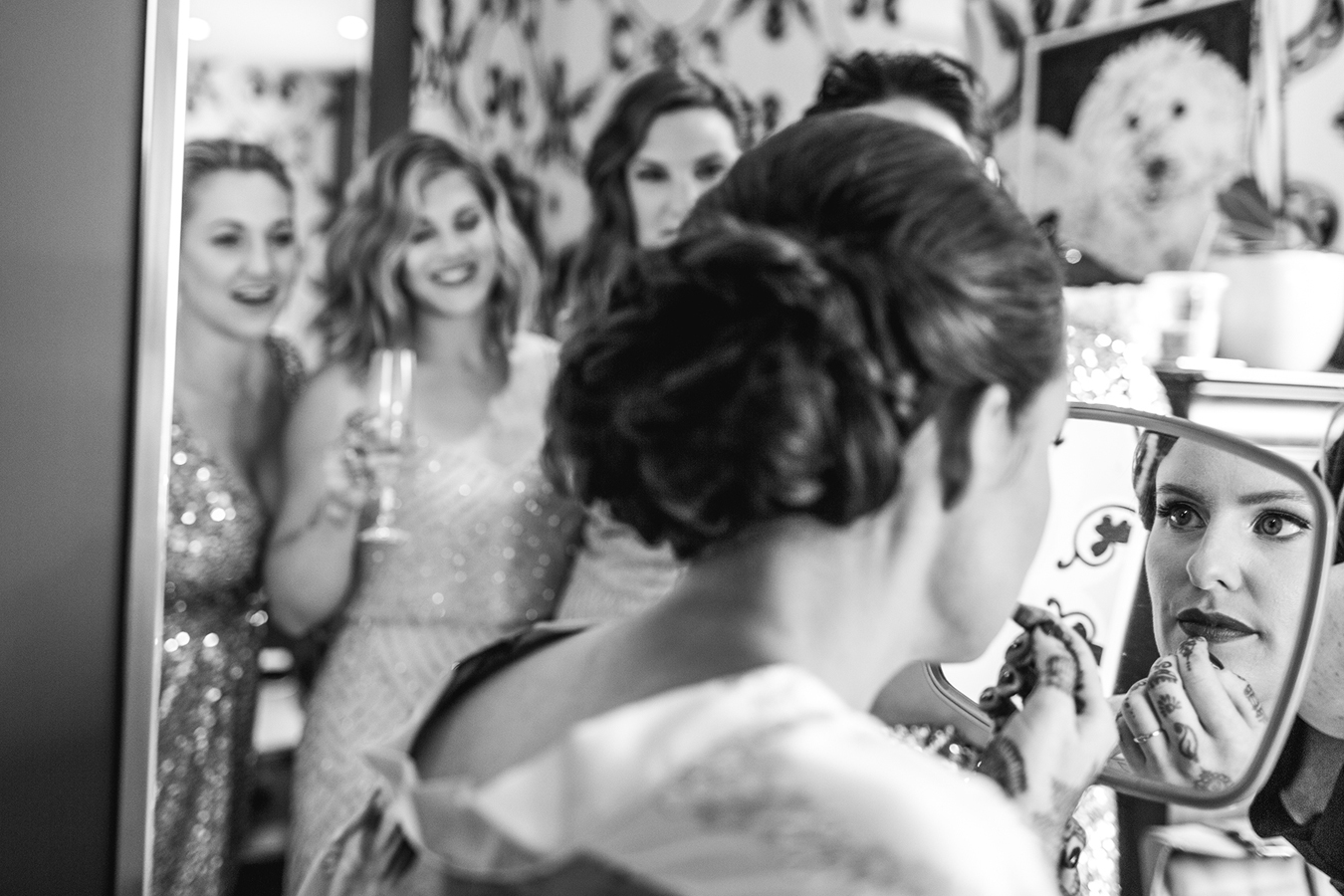 bridesmaids watch the bride putting her lipstick on