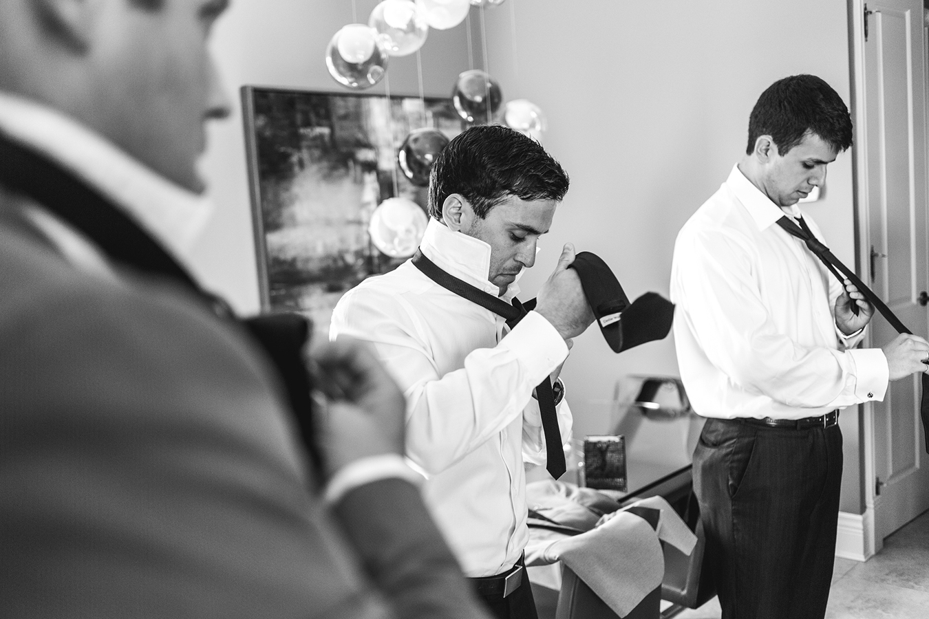 groomsmen tie their ties while getting ready for a Vancouver wedding