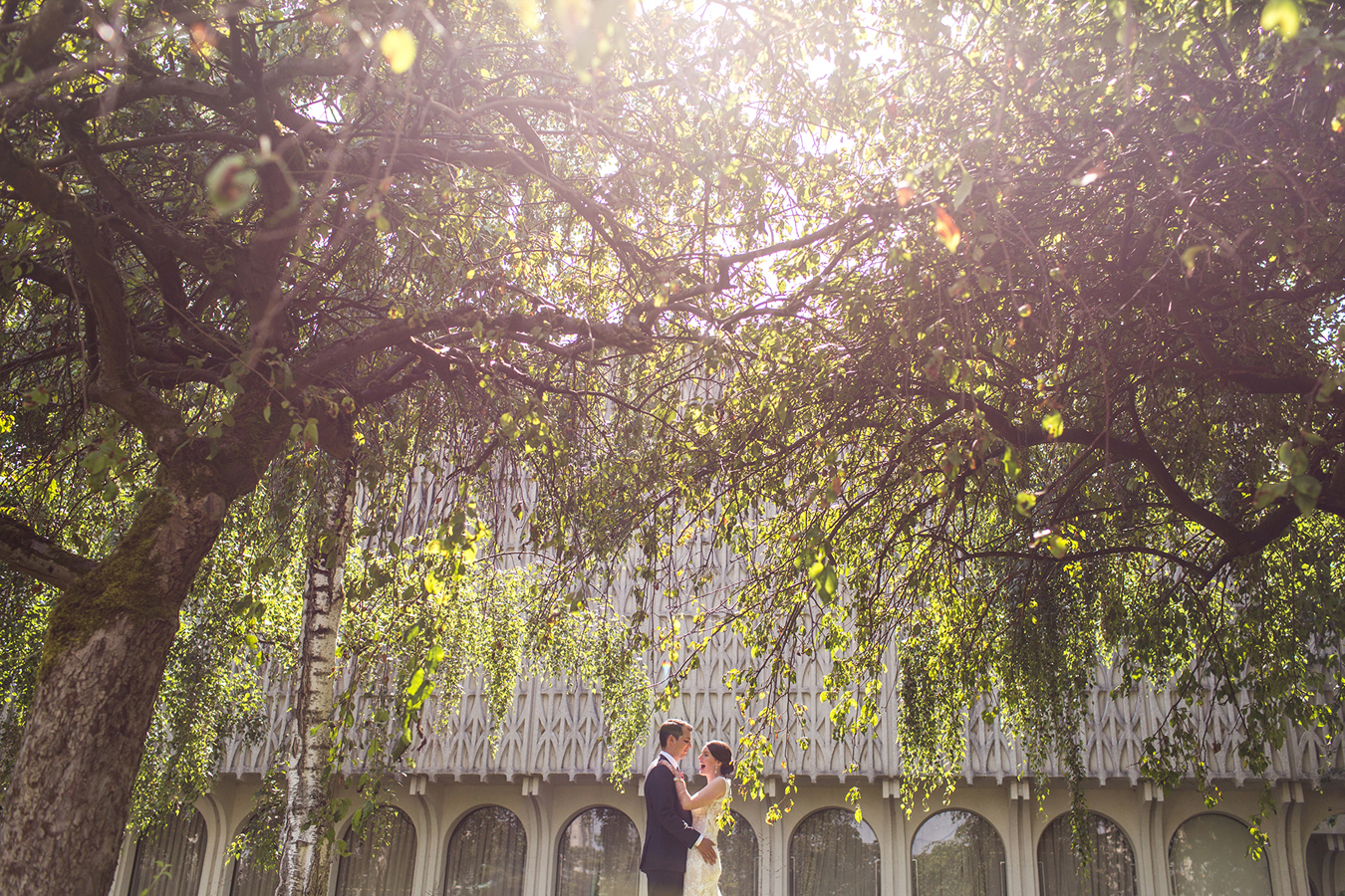 newlyweds share a moment of joy underneath willow trees at Vanier Park in Vancouver BC
