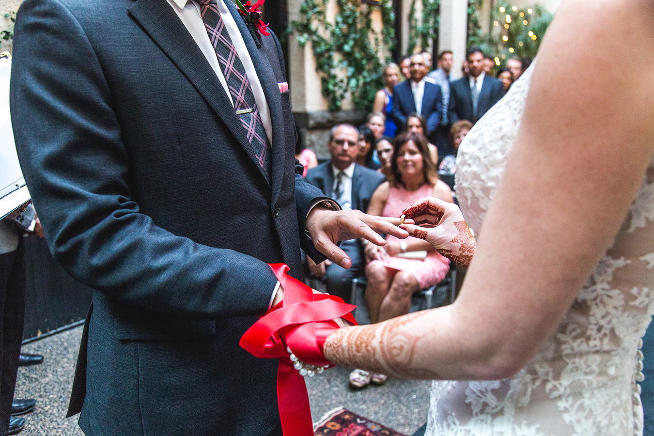 Parents watch as a couple exchanges wedding rings with fasted hands at a small wedding ceremony in Vancouver