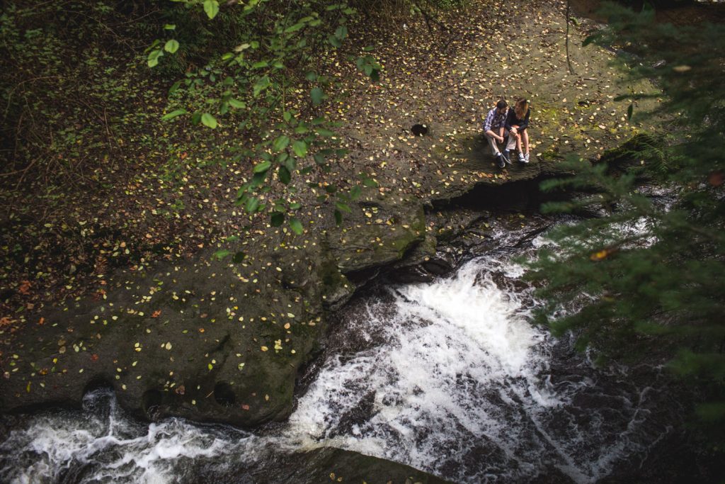 a couple rests on the cliffs above kanaka falls