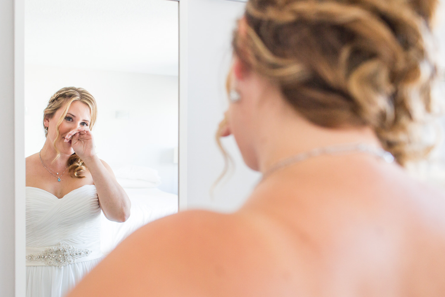 bride cries as she sees herself in the mirror