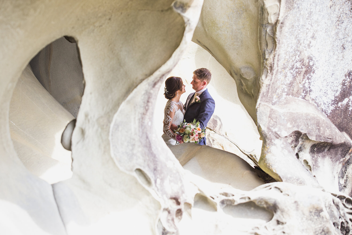 A bride and groom embrace at Retreat Cove on Galiano Island