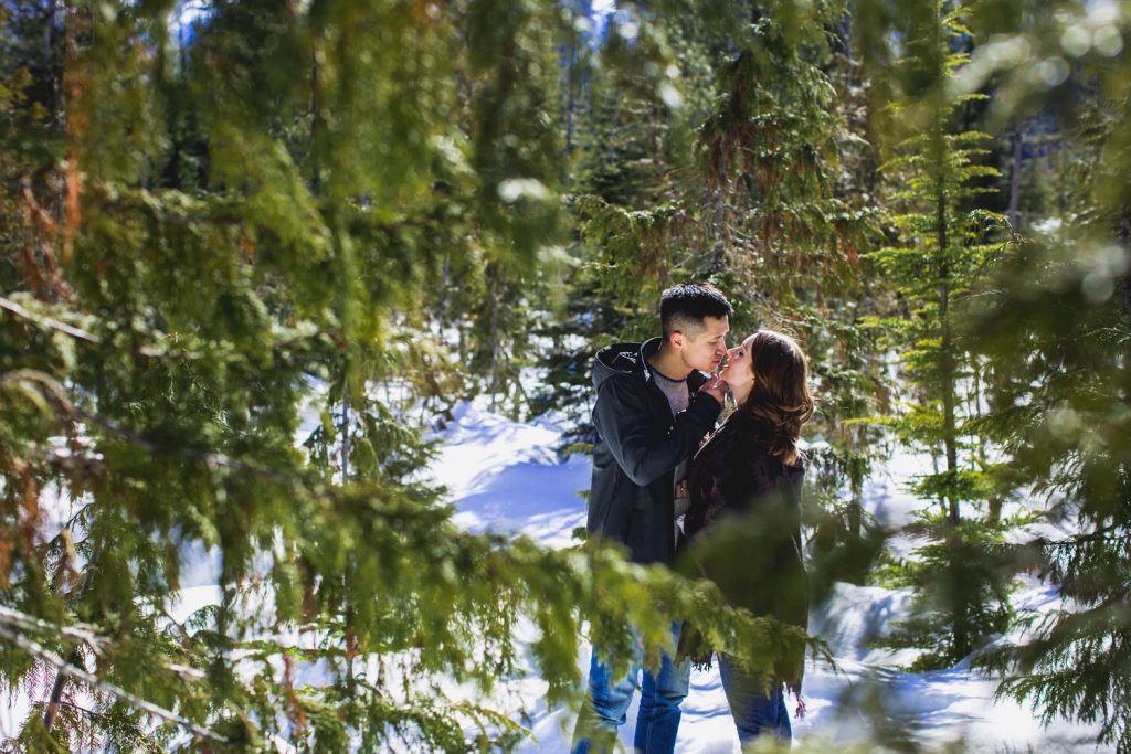 couple snowshoes along a trail at a sea to sky gondola engagement session in Howe Sound