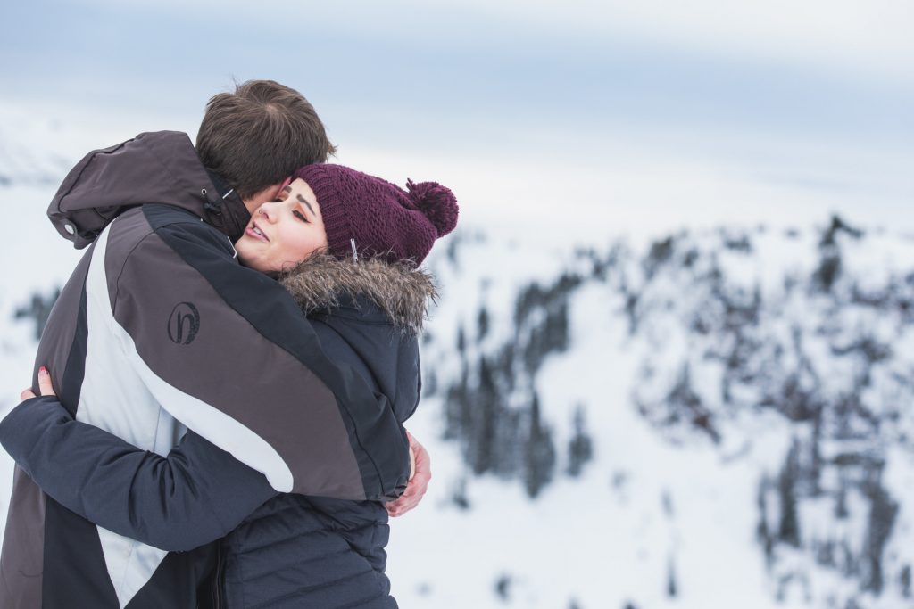 a man and a woman embrace in the snow